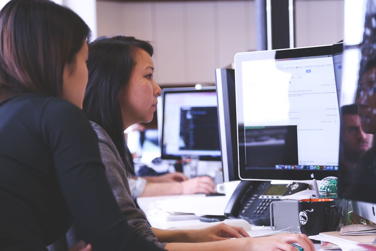 Two coworkers working on a computer.